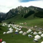 Des yourtes blanches dans une vallée verdoyante
