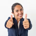 Une jeune femme d'affaires souriante en tailleur bleu marine faisant un double pouce en l'air